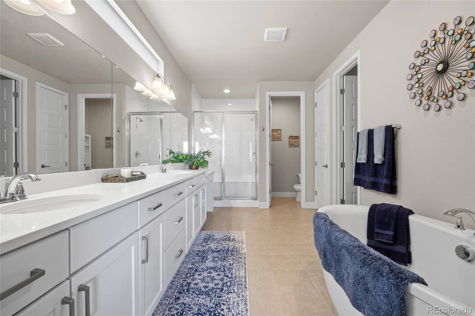 164 Rockingham Circle Castle Pines, CO 80108 - Photo 13 of 43 a large bathroom with a double vanity sink and a mirror