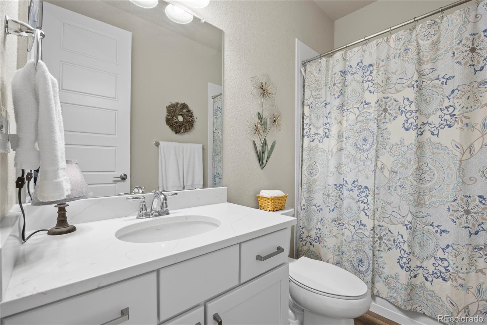 164 Rockingham Circle Castle Pines, CO 80108 - Photo 17 of 43 a bathroom with a sink a toilet and a mirror