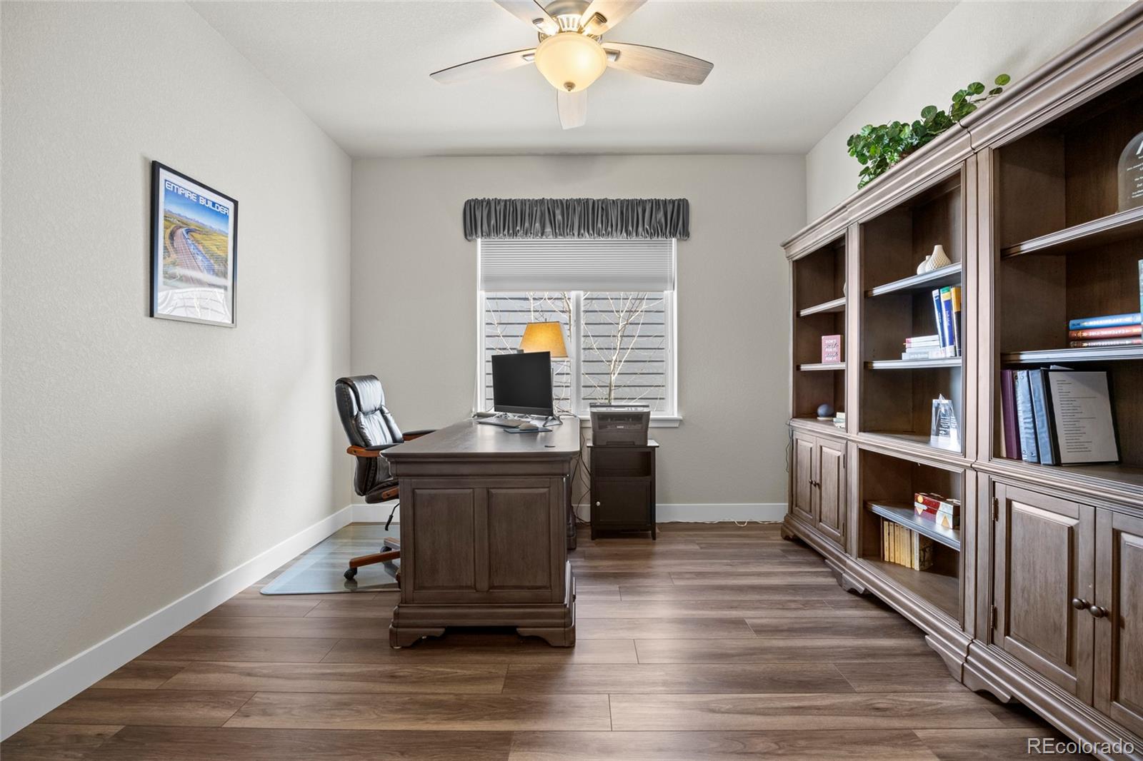 164 Rockingham Circle Castle Pines, CO 80108 - Photo 18 of 43 a workspace with furniture bookshelf and wooden floor