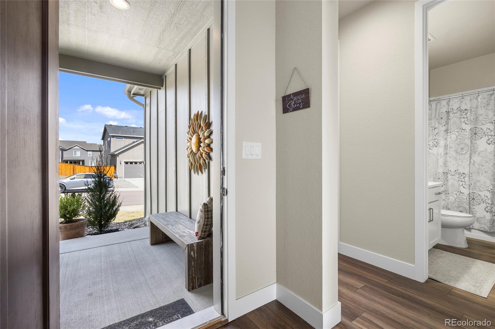 164 Rockingham Circle Castle Pines, CO 80108 - Photo 3 of 43 a view of a hallway with wooden floor and a livingroom