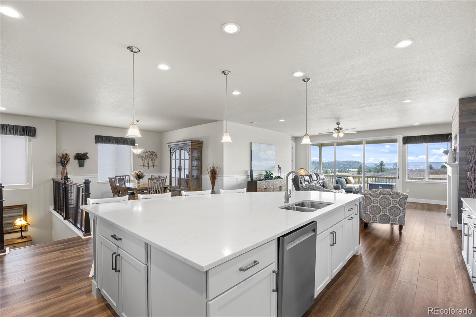 164 Rockingham Circle Castle Pines, CO 80108 - Photo 4 of 43 a kitchen with a sink a counter top space stainless steel appliances and wooden floor