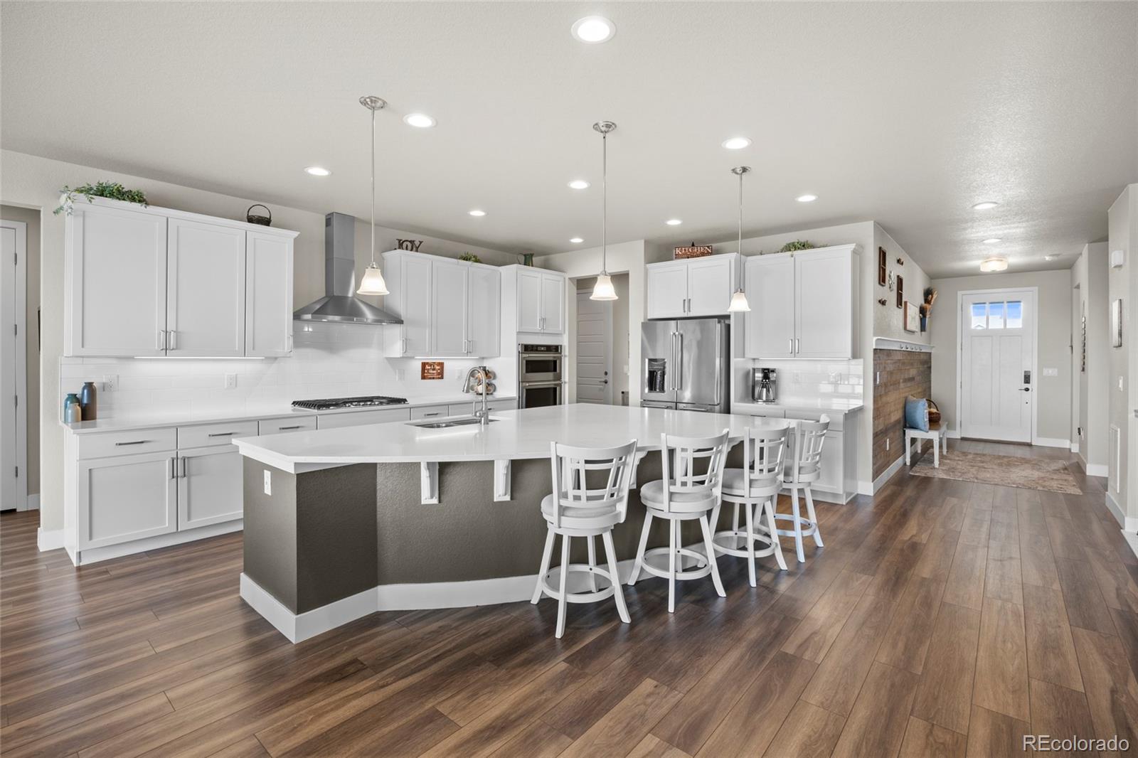 164 Rockingham Circle Castle Pines, CO 80108 - Photo 5 of 43 a kitchen with stainless steel appliances granite countertop a table chairs sink refrigerator and microwave