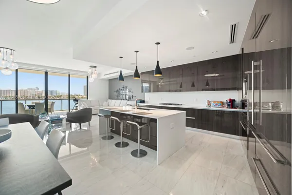 a large white kitchen with a large window and stainless steel appliances