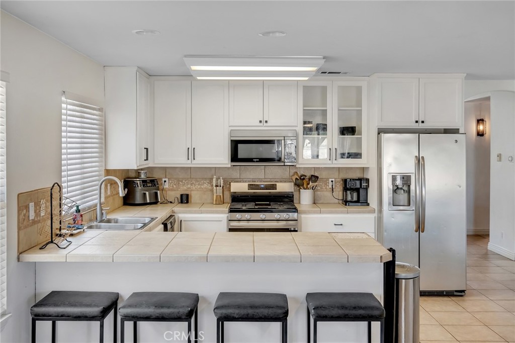 14952 Rivers Edge Road Helendale, CA 92342 - Photo 16 of 33 a kitchen with stainless steel appliances a stove a refrigerator and a dining table
