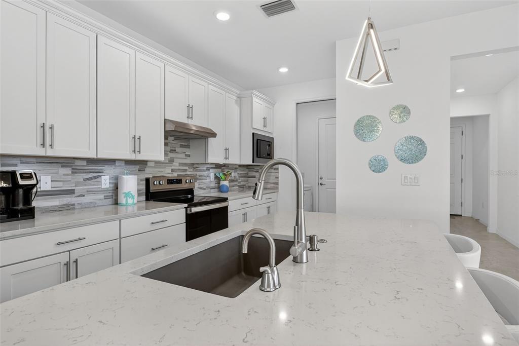 1319 Raspberry Dr Port North Port, FL 34289 - Photo 7 of 70 a kitchen with stainless steel appliances a refrigerator sink and cabinets