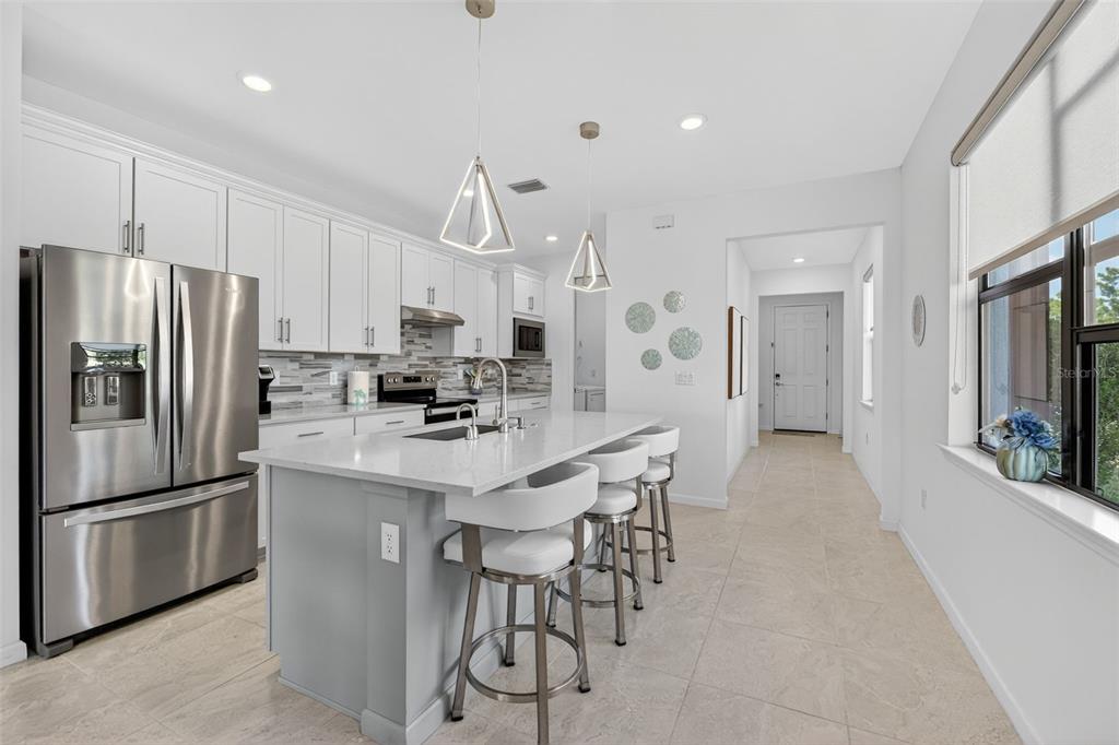 1319 Raspberry Dr Port North Port, FL 34289 - Photo 8 of 70 a kitchen with stainless steel appliances a refrigerator stove microwave and cabinets