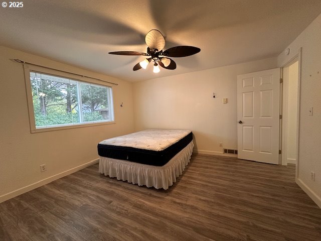 3932 Spruce Street Florence, OR 97439 - Photo 14 of 39 an empty room with wooden floor fan and windows