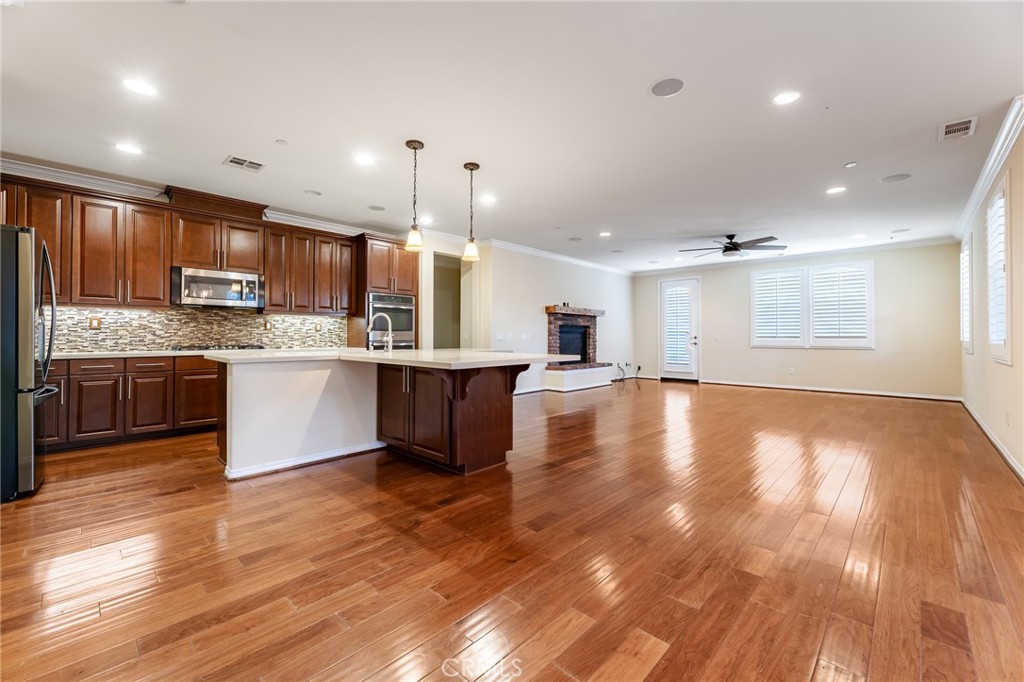 26459 Riverrock Way Saugus, CA 91350 - Photo 13 of 60 a large kitchen with stainless steel appliances granite countertop a large kitchen island a sink a stove and a wooden floors