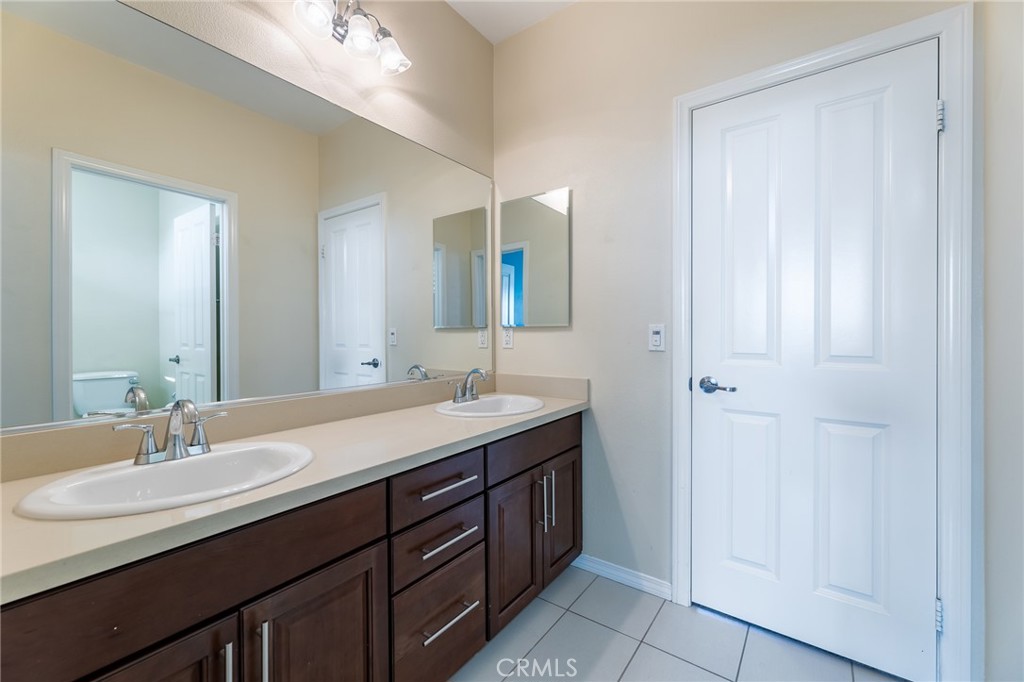 26459 Riverrock Way Saugus, CA 91350 - Photo 37 of 60 a bathroom with a double vanity sink and a mirror
