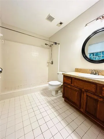 a bathroom with a granite countertop sink a toilet and a mirror