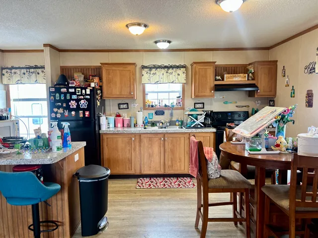 a kitchen with a dining table chairs and a refrigerator