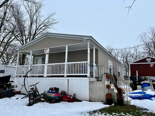 a view of a house with a patio and a car parked in a yard