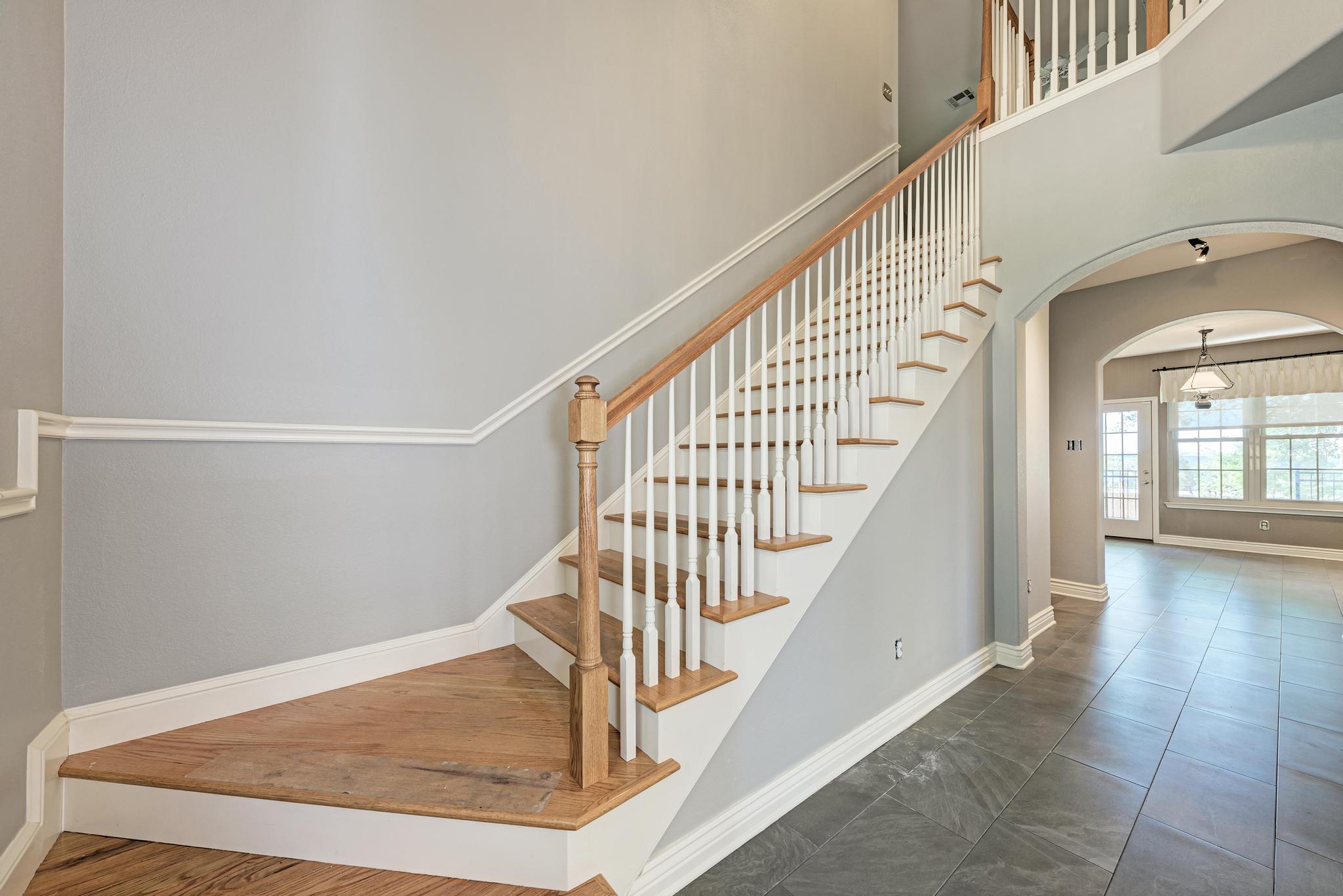 906 Antelope Ridge Cedar Park, TX 78613 - Photo 20 of 40 An elegant staircase with wood treads leads upward from the tiled entry foyer.