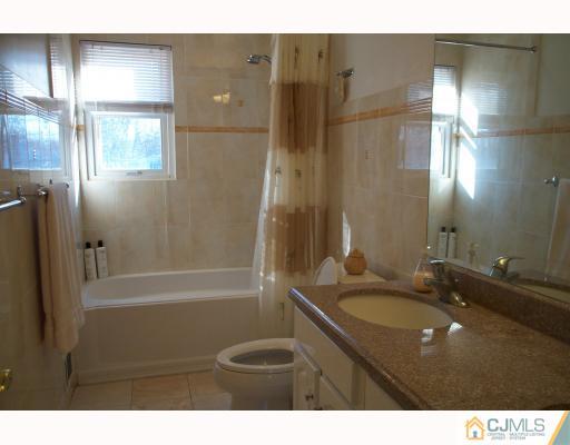 10 Sulliman Road Edison, NJ 08817 - Photo 8 of 9 a bathroom with a sink double vanity granite tub shower and a mirror