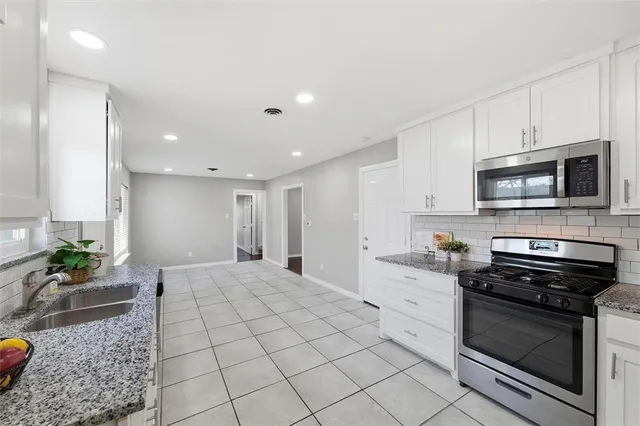 a kitchen with stainless steel appliances kitchen island granite countertop a stove a sink and a microwave
