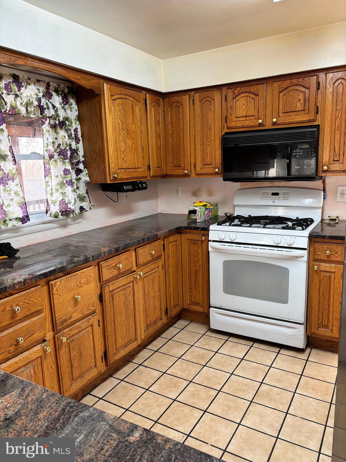 148 Diamond Avenue Pine Hill, NJ 08021 - Photo 18 of 35 a kitchen with granite countertop a stove top oven microwave and cabinets