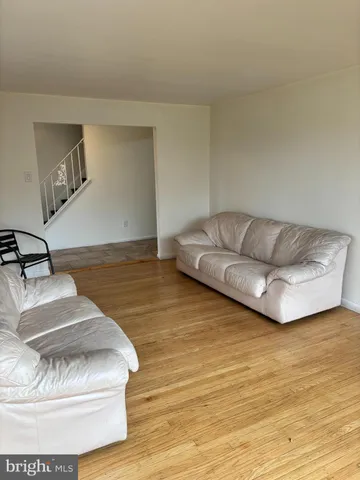 a living room with couch and a wooden floor