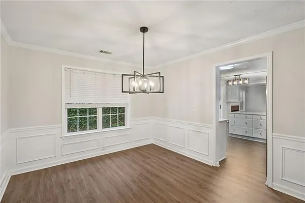 a view of empty room with wooden floor and window