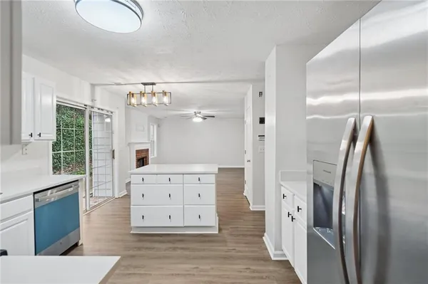 a view of kitchen with stainless steel appliances cabinets and wooden floor