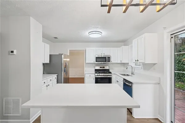 a large white kitchen with stainless steel appliances
