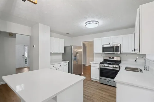 a kitchen with stainless steel appliances a refrigerator stove microwave and cabinets