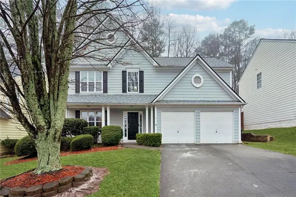 a front view of a house with a yard and garage