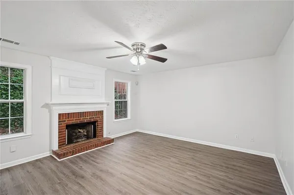 an empty room with windows a fireplace