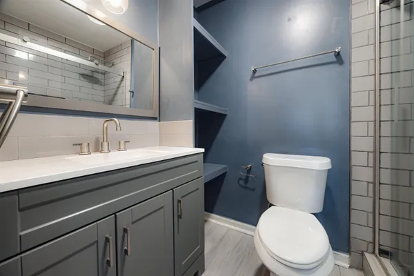 a bathroom with a toilet a sink and mirror