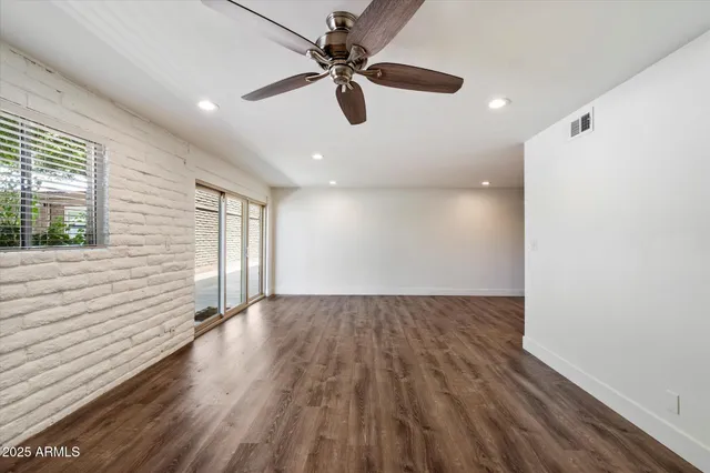 a view of an empty room and window with wooden floor