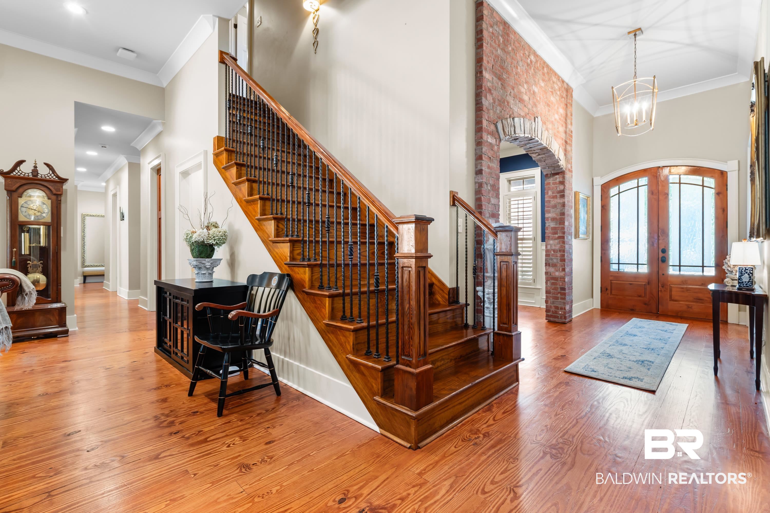 30057 Dolive Ridge Daphne, AL 36527 - Photo 12 of 55 Foyer entrance featuring wood-type flooring, crown molding, a towering ceiling, and french doors