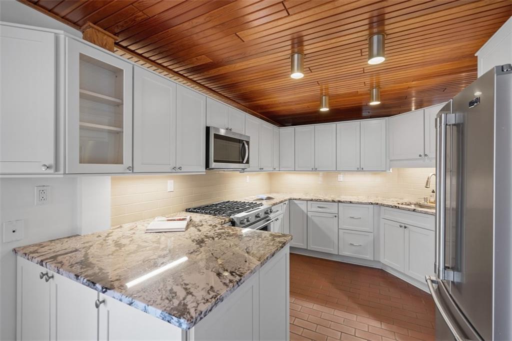 5 Bayard Road, Unit 219 Pittsburgh, PA 15213 - Photo 6 of 35 a kitchen with granite countertop a sink a stove and cabinets