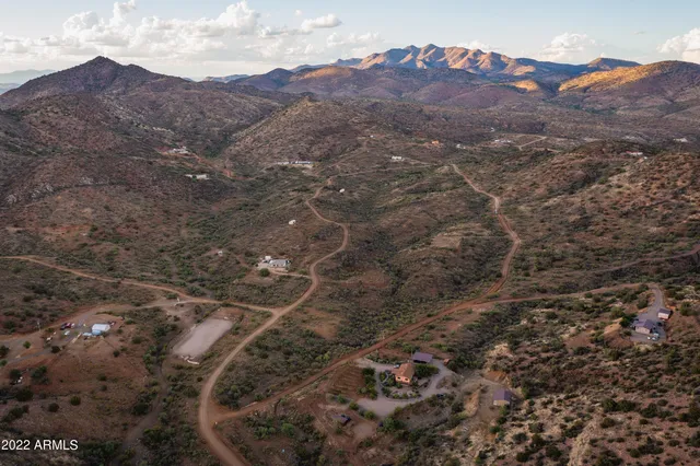 a view of a dry yard with mountains in the background