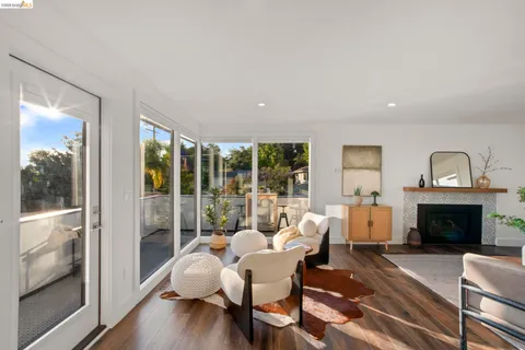 a living room with furniture a fireplace and a large window