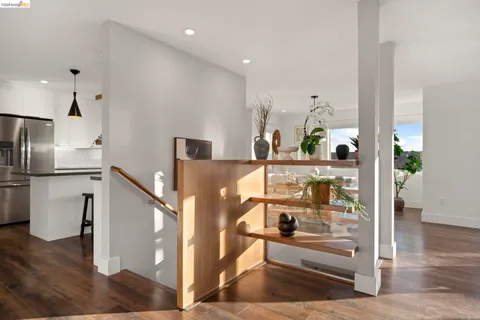 a kitchen with stainless steel appliances granite countertop a sink counter space and living room view