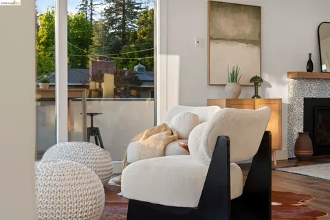 a living room with furniture a fireplace and floor to ceiling windows
