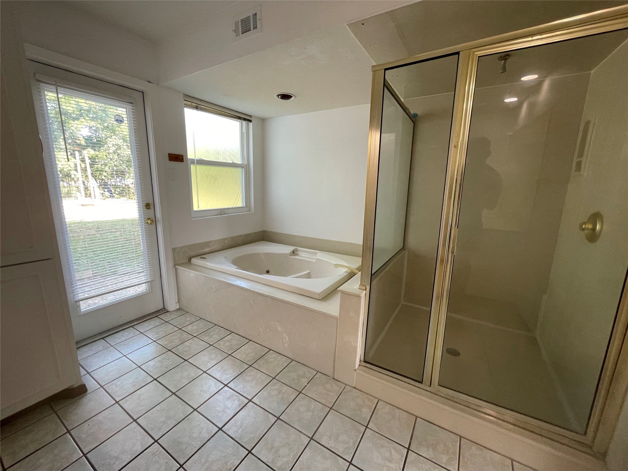 5802 Longhorn Landing Austin, TX 78734 - Photo 28 of 38 Full bath featuring a stall shower, a jetted tub, and light tile patterned flooring