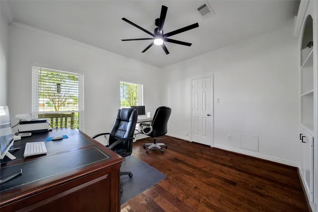 a view of a workspace with furniture and a window