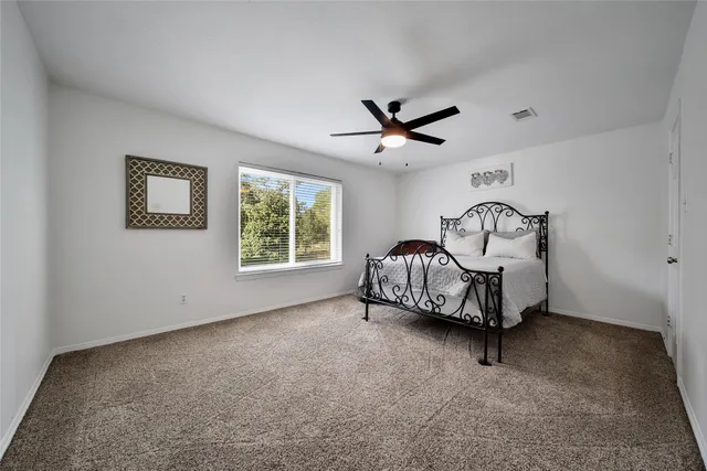 a living room with furniture a window and a ceiling fan