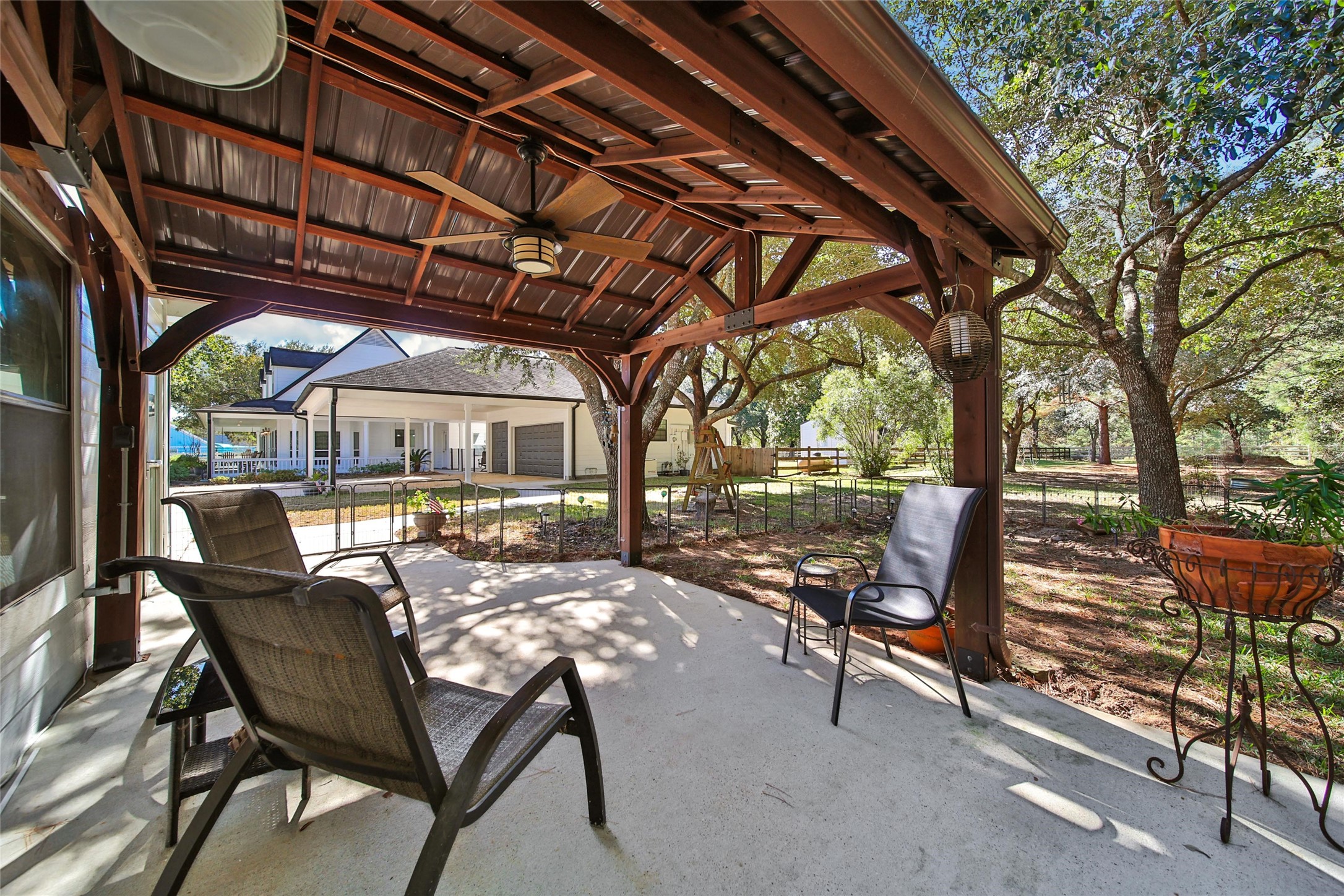 29919 Tudor Way Magnolia, TX 77355 - Photo 36 of 50 a view of a patio with table and chairs and couches with wooden floor and fence
