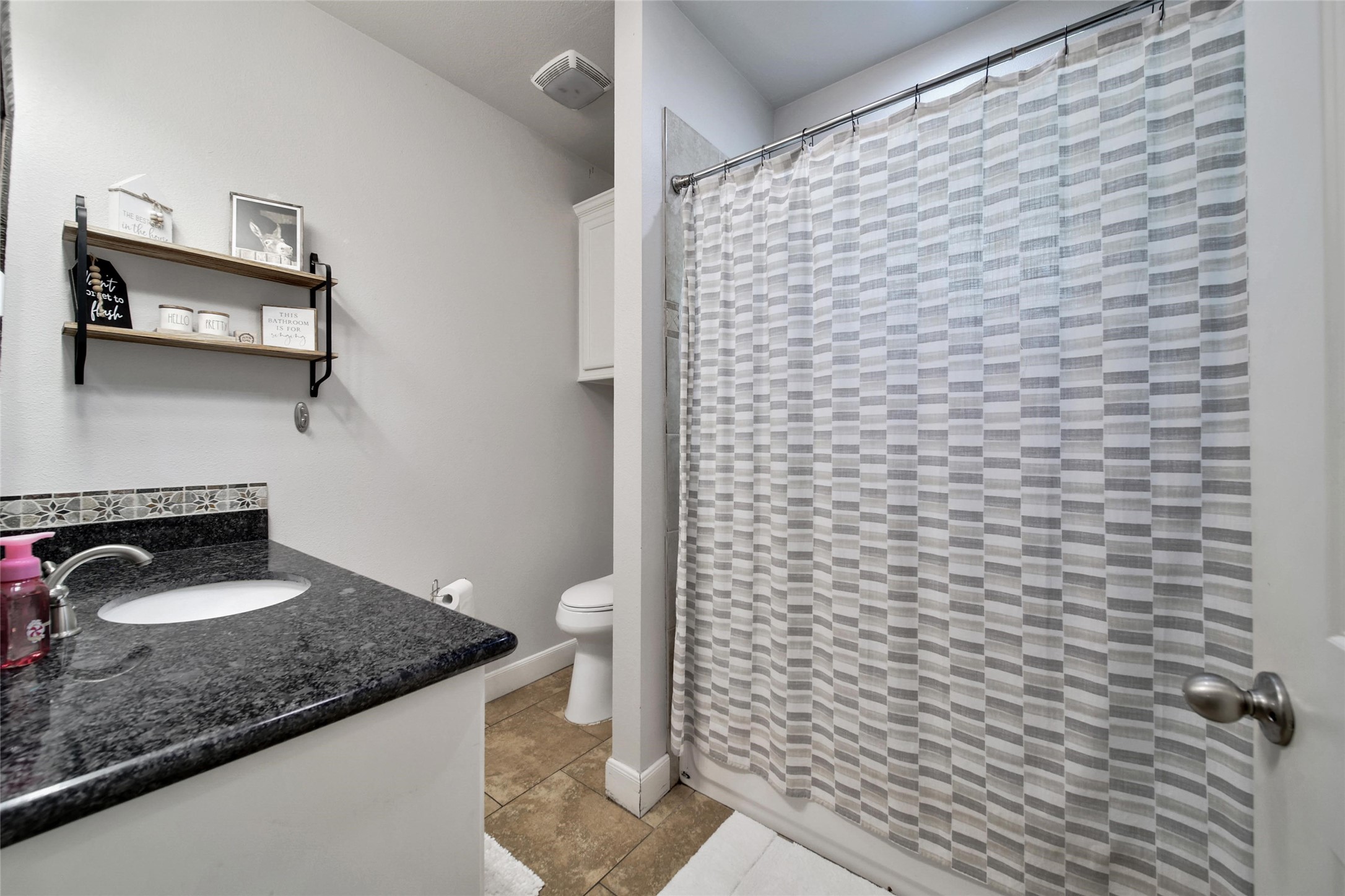 29919 Tudor Way Magnolia, TX 77355 - Photo 41 of 50 a bathroom with a granite countertop sink a toilet and a mirror
