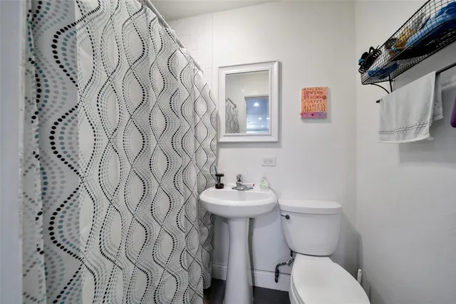 a bathroom with a sink toilet and a mirror