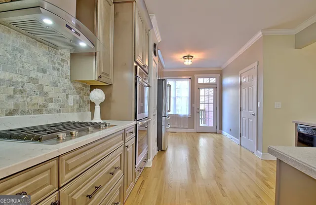 a kitchen with stainless steel appliances granite countertop a stove a sink and a refrigerator