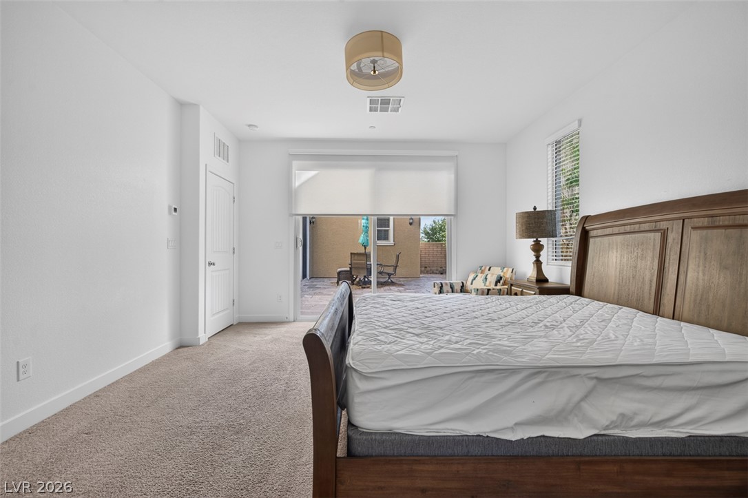 1100 East Sunset Road Henderson, NV 89011 - Photo 19 of 58 Relax in this well-lit bedroom featuring a private patio entrance for seamless indoor-outdoor living.