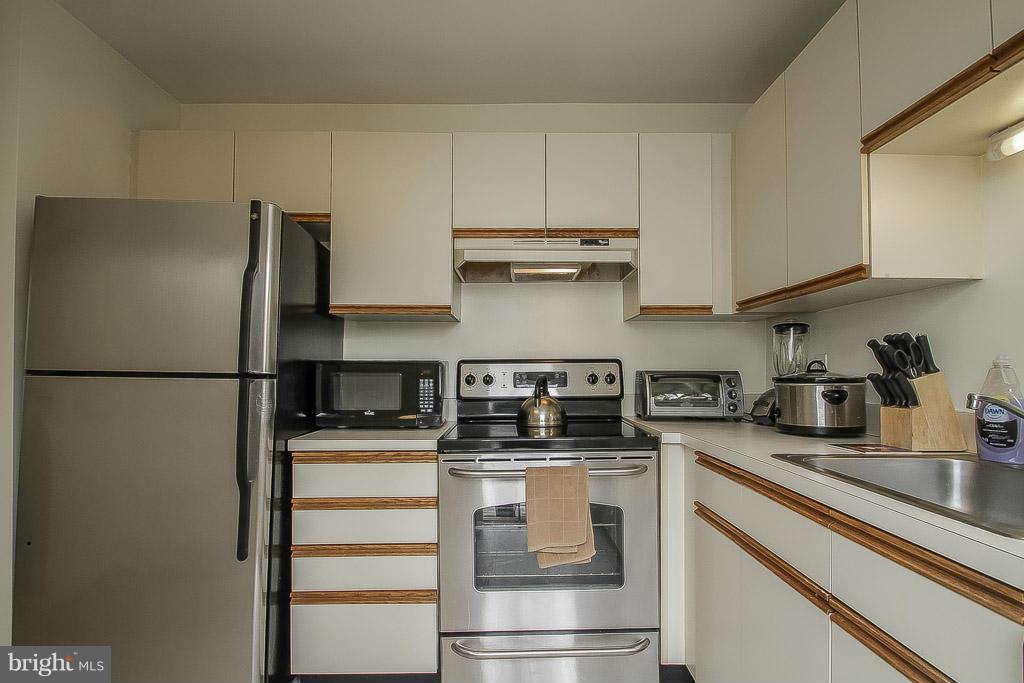 11029 Sentry Ridge Road, Unit 11 Manassas, VA 20109 - Photo 11 of 30 a kitchen with stainless steel appliances a refrigerator sink and cabinets