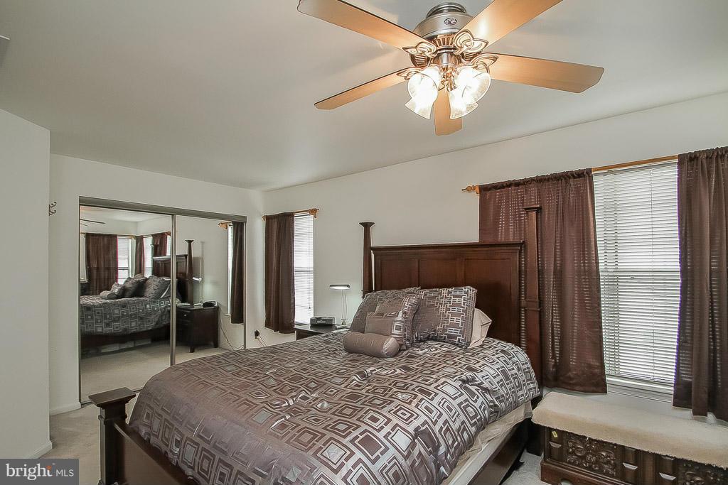 11029 Sentry Ridge Road, Unit 11 Manassas, VA 20109 - Photo 14 of 30 a bedroom with a bed and a chandelier