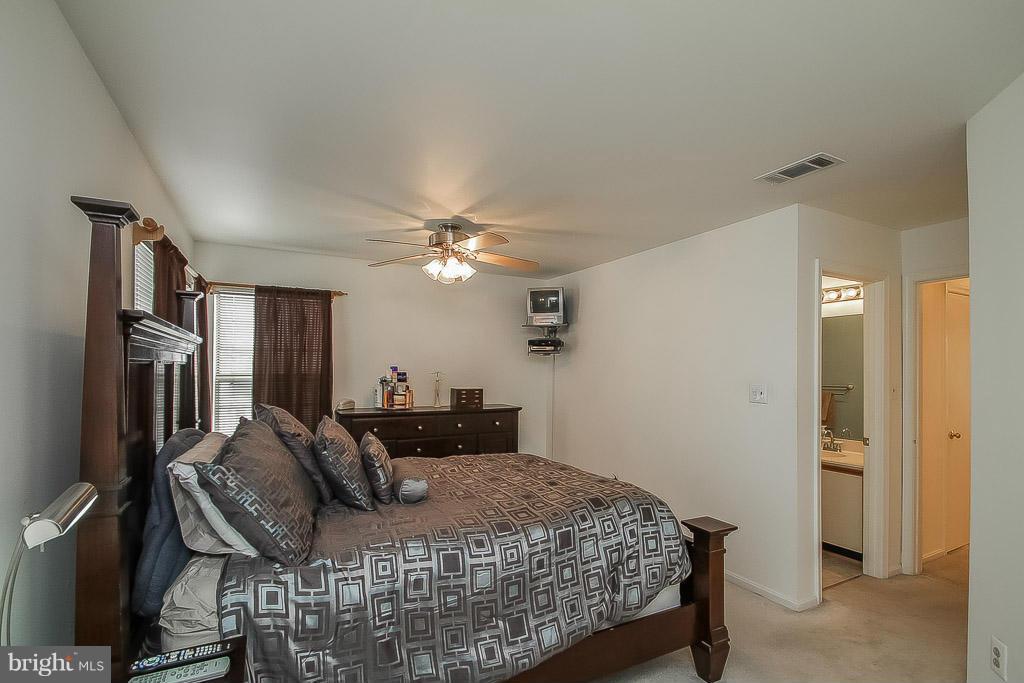 11029 Sentry Ridge Road, Unit 11 Manassas, VA 20109 - Photo 15 of 30 a bedroom with a bed and a chandelier