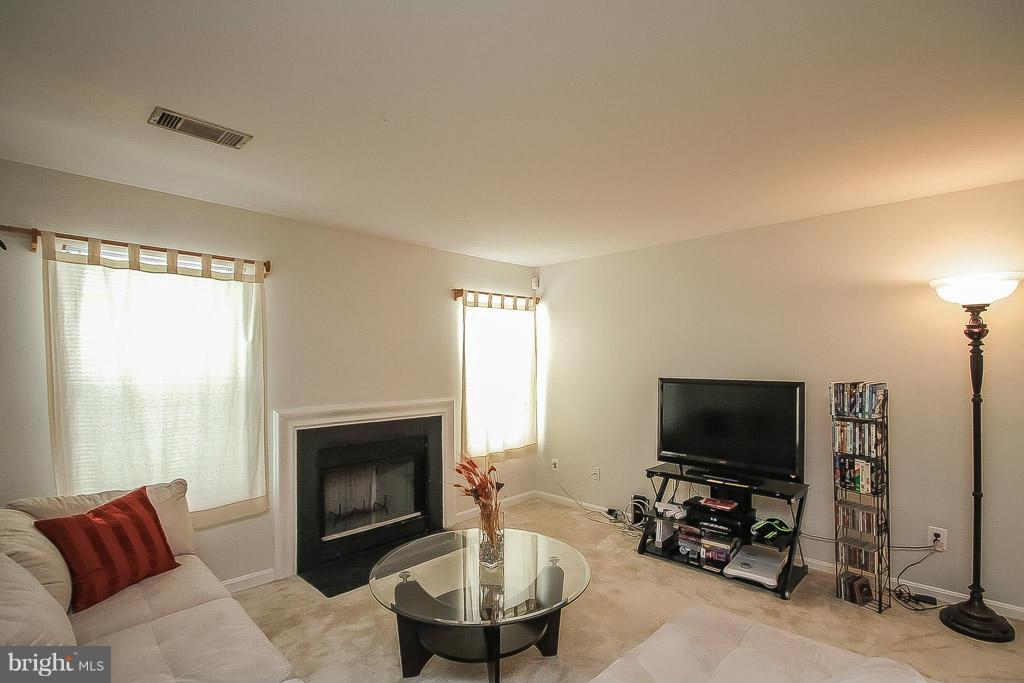 11029 Sentry Ridge Road, Unit 11 Manassas, VA 20109 - Photo 3 of 30 a living room with furniture a flat screen tv and a fireplace