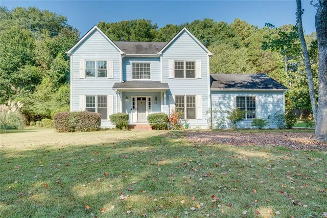 a front view of a house with yard and green space