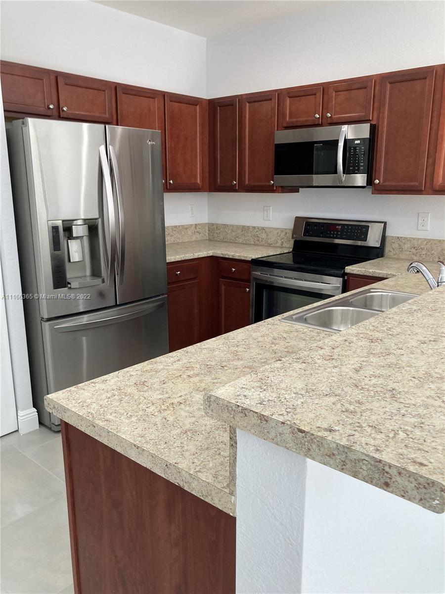 The Hammocks Miami, FL 33196 - Photo 11 of 27 a kitchen with granite countertop a refrigerator and a sink