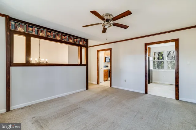 an empty room with window and ceiling fan